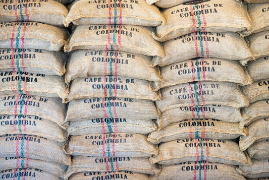 Stacked jute sacks of green coffee from Colombia, ready for export