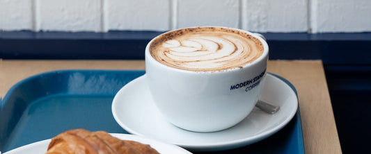 Cappuccino and croissant on a serving tray