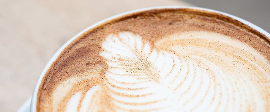 Chai latte with latte art and a dusting of cinnamon