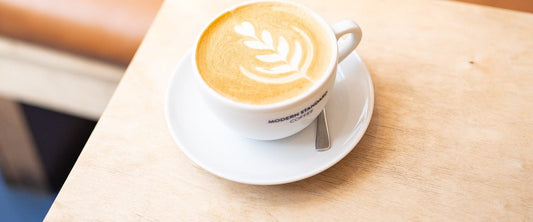 Cortado with latte art in a café booth