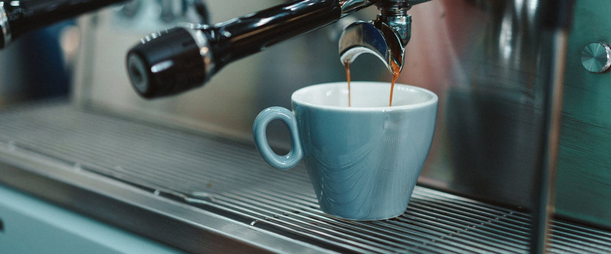 Espresso pouring into a blue cup