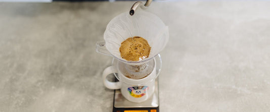 Pouring water over coffee in a V60 dripper on scales