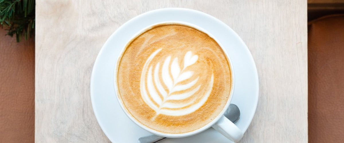 Festive latte with latte art and Christmas greenery