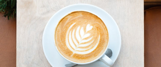 Festive latte with latte art and Christmas greenery