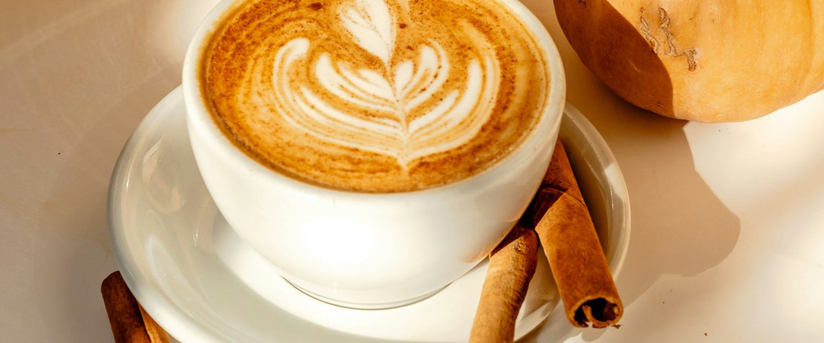Pumpkin spice latte topped with cinnamon in an autumn setting