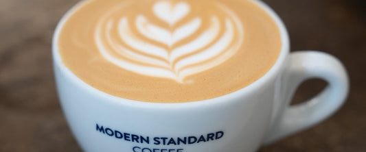 Vanilla latte with latte art in a Modern Standard Coffee cup