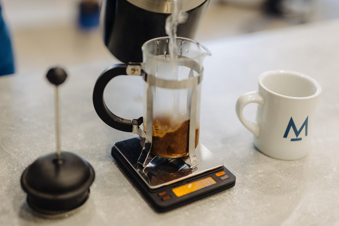 Pouring the first water onto coffee in a cafetière