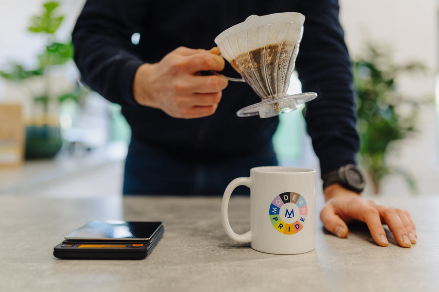 A V60 dripper and paper filter held over a Modern Standard Pride mug