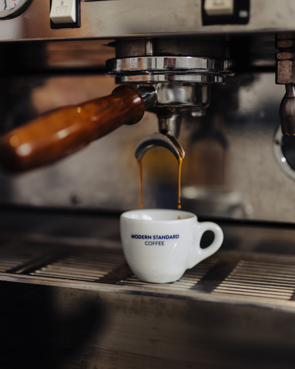 An espresso shot pouring into a Modern Standard Coffee cup