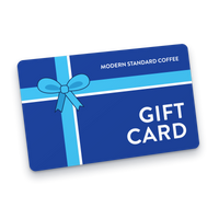 Modern Standard Coffee gift card: a dark blue card wrapped in a light blue ribbon and bow, sent by email