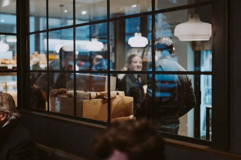 Customers queuing inside the Ole & Steen bakery café seen through the window