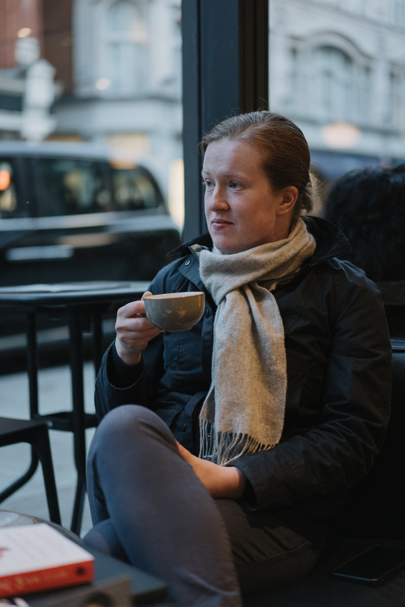 Customer enjoying a cup of tea at a window seat at Ole & Steen