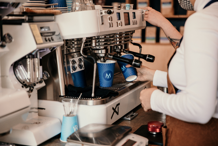 Espresso pouring from a commercial machine into a Modern Standard cup